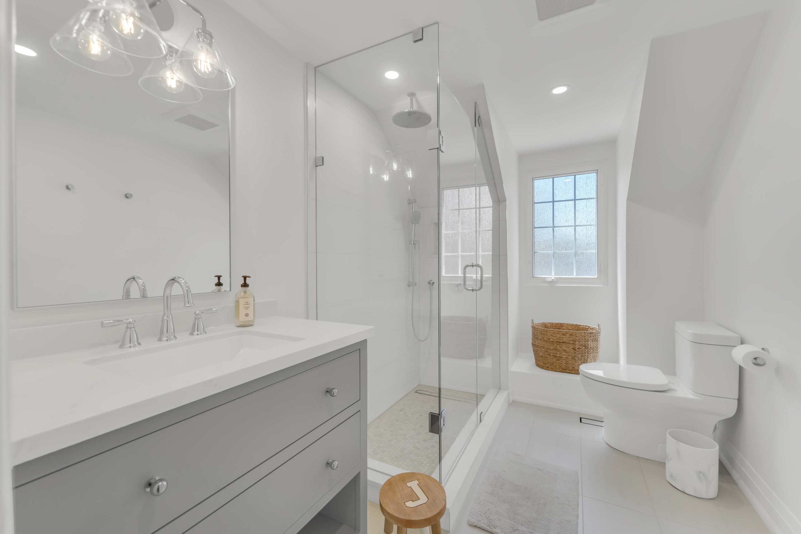 Porcelain Tile in a Modern Bathroom Modern white bathroom with porcelain floor and wall tiles, glass shower and grey vanity